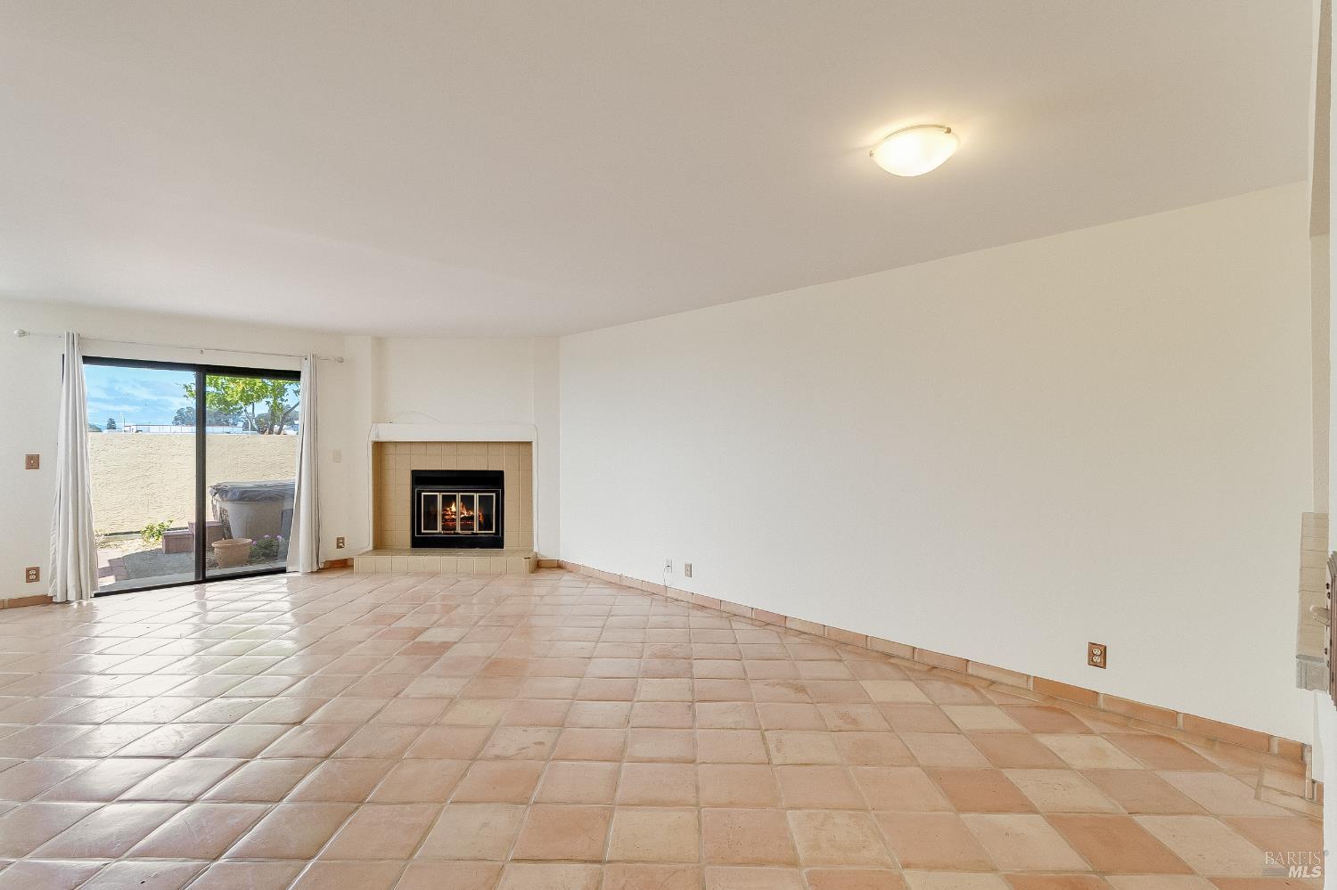 171 Nantucket Lane Vallejo, CA 94590 - Photo 8 of 56 a view of an empty room with a fireplace and a window