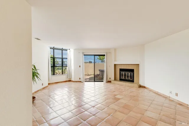 a view of an empty room with a fireplace and a window