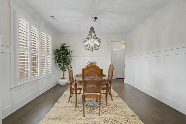 a dining room with furniture a chandelier and wooden floor