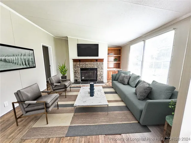 a living room with furniture fireplace and a large window