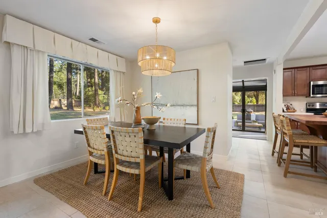a view of a dining room with furniture a chandelier and wooden floor