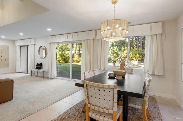 a kitchen with a refrigerator a microwave a sink and a dining table