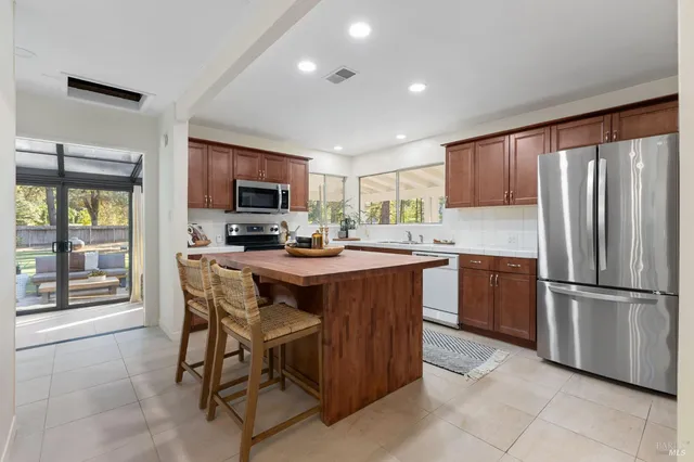 a kitchen with stainless steel appliances granite countertop a sink a stove and a refrigerator