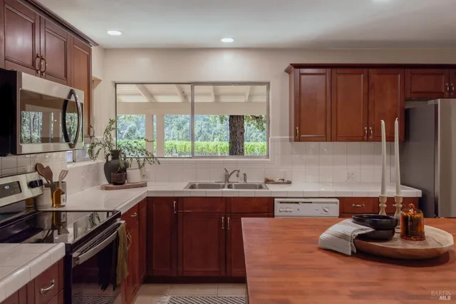 a kitchen with a sink stove top oven and cabinets