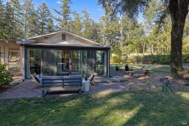 a view of a house with backyard and sitting area