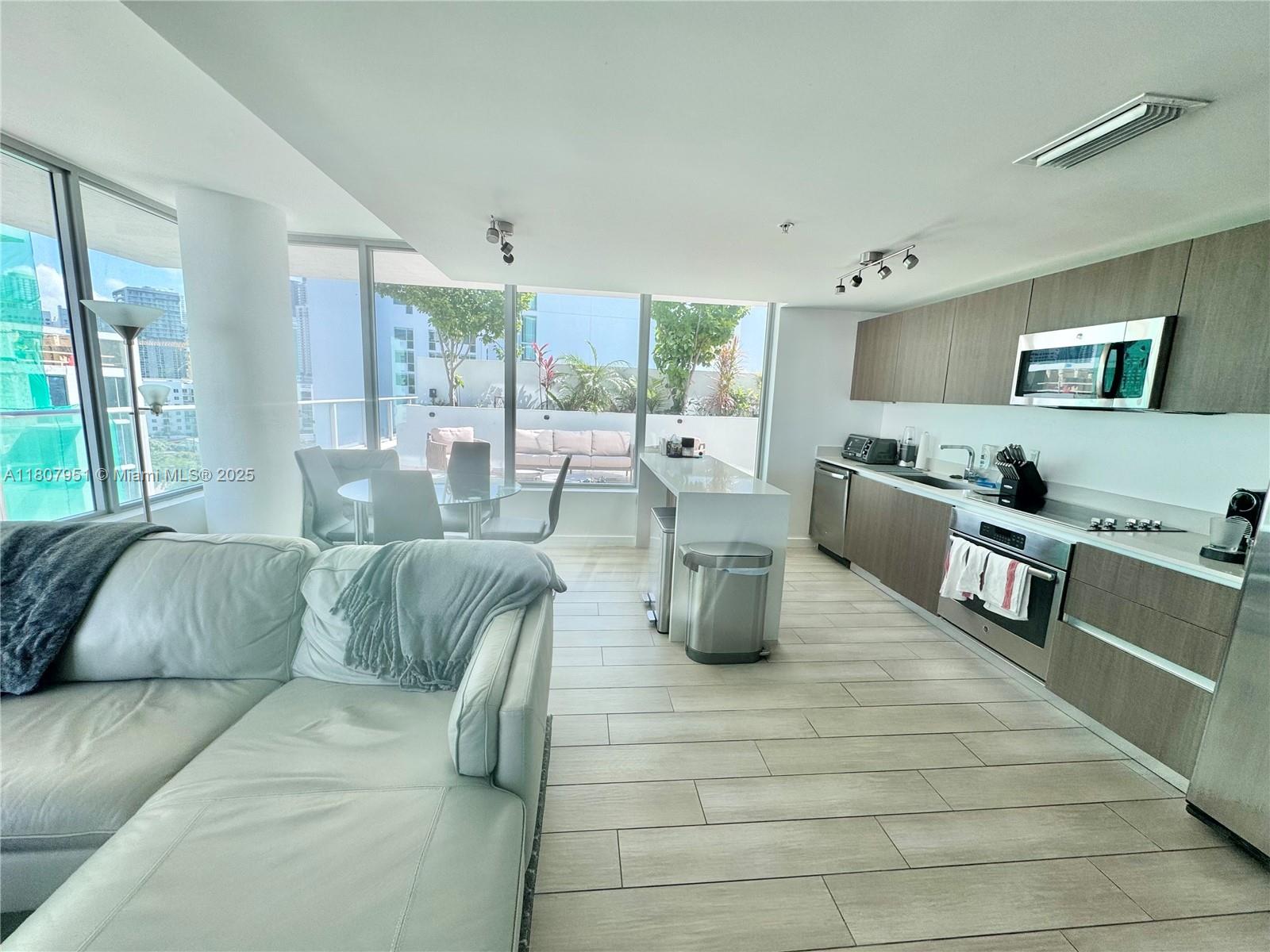 1600 Southwest 1st Avenue, Unit 910 Miami, FL 33129 - Photo 2 of 11 a living room with furniture and a flat screen tv