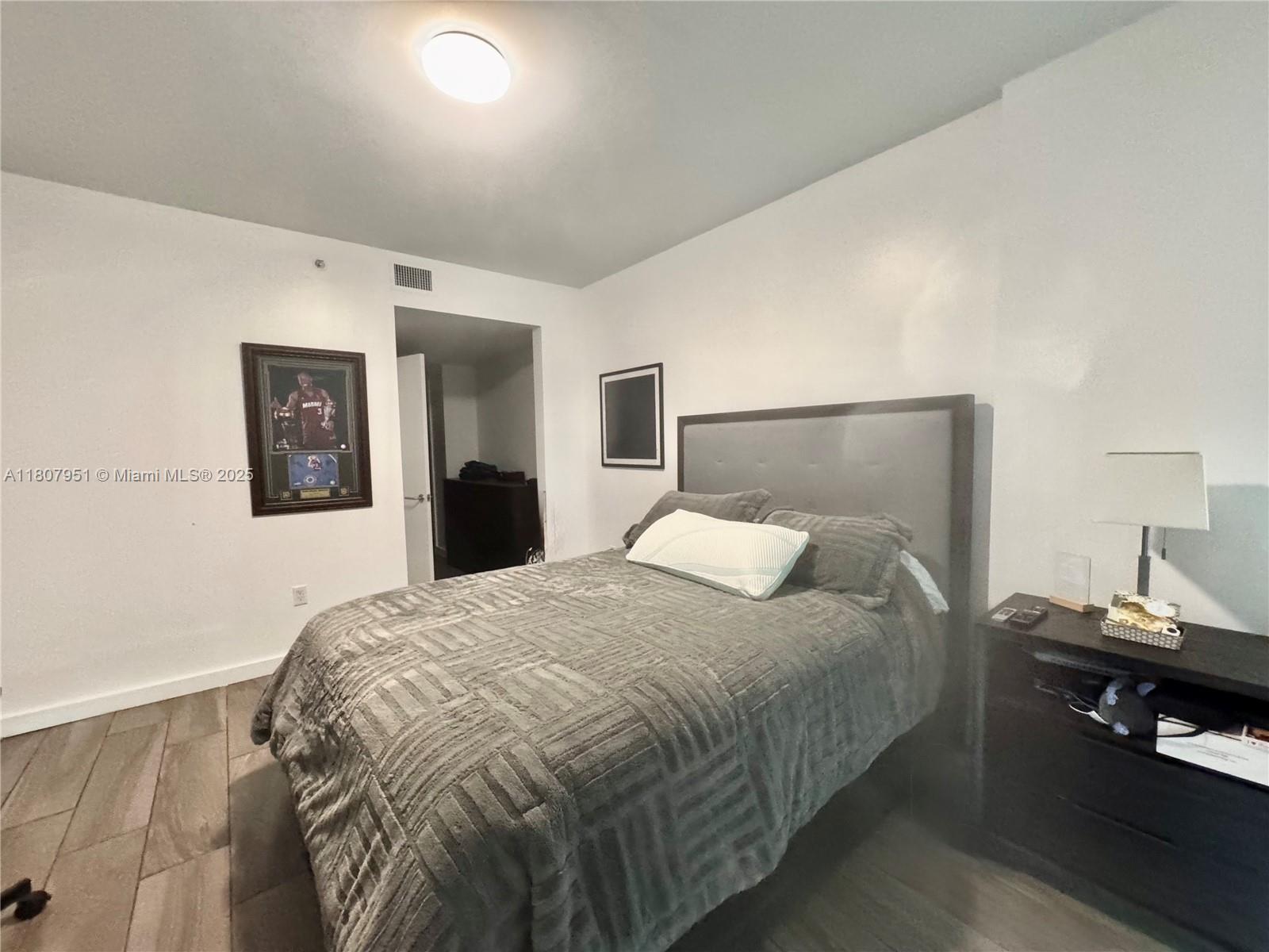 1600 Southwest 1st Avenue, Unit 910 Miami, FL 33129 - Photo 6 of 11 a bedroom with a bed and wooden floor