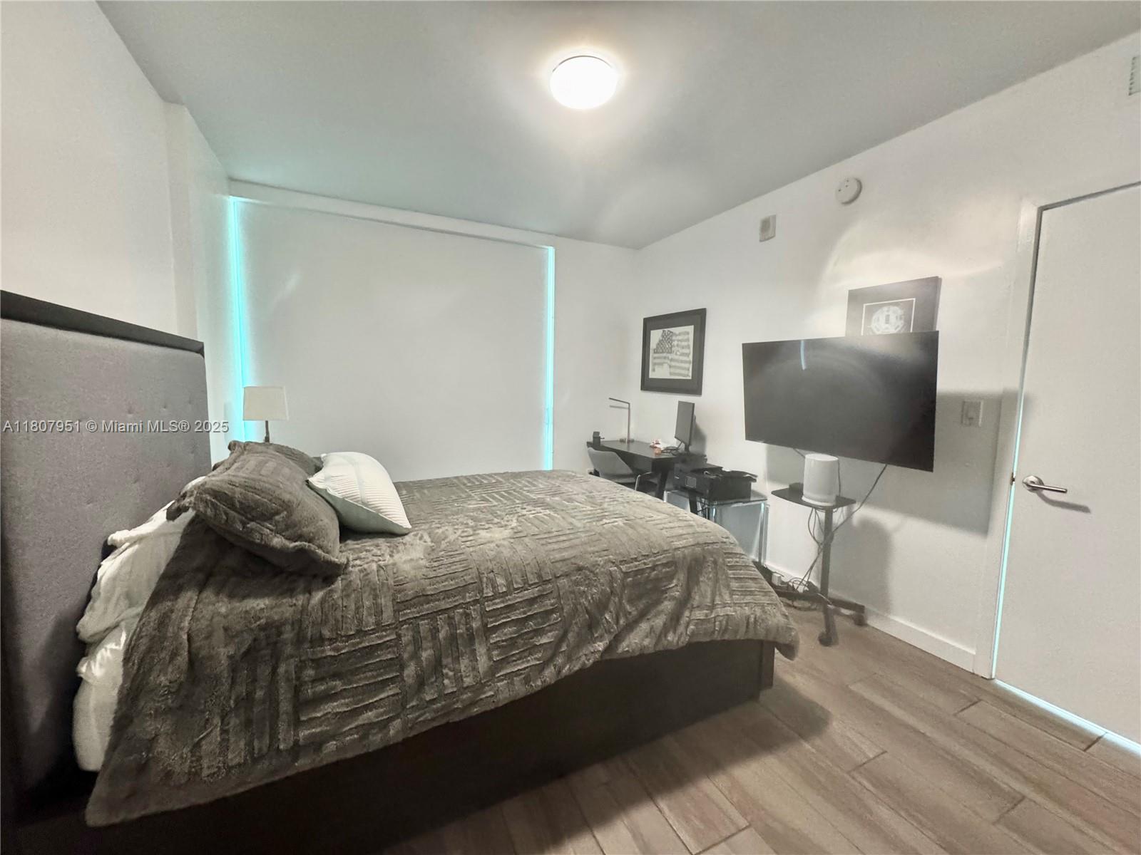 1600 Southwest 1st Avenue, Unit 910 Miami, FL 33129 - Photo 7 of 11 a bedroom with a bed and a flat screen tv