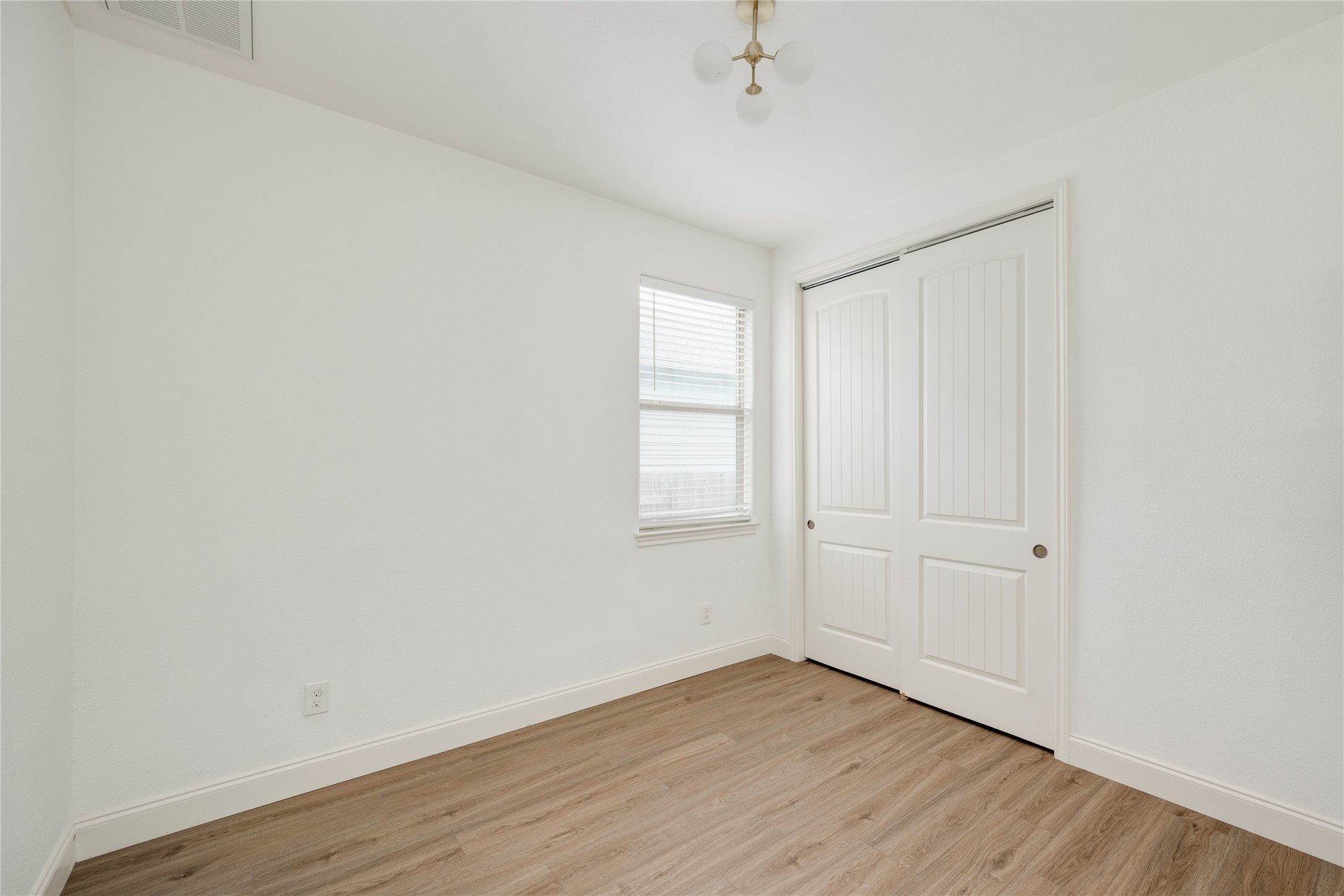 6008 Whipple Way Austin, TX 78745 - Photo 26 of 39 A well-lit bedroom features durable laminate flooring and a spacious sliding door closet.