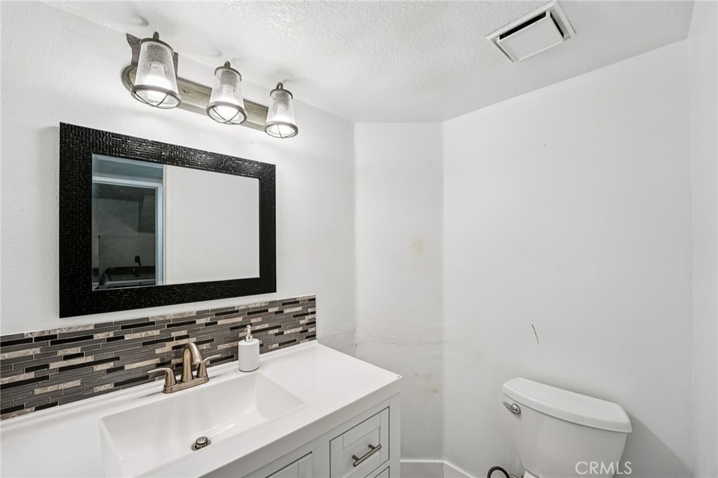17586 Mountain Court Riverside, CA 92503 - Photo 11 of 39 a bathroom with a toilet sink and mirror