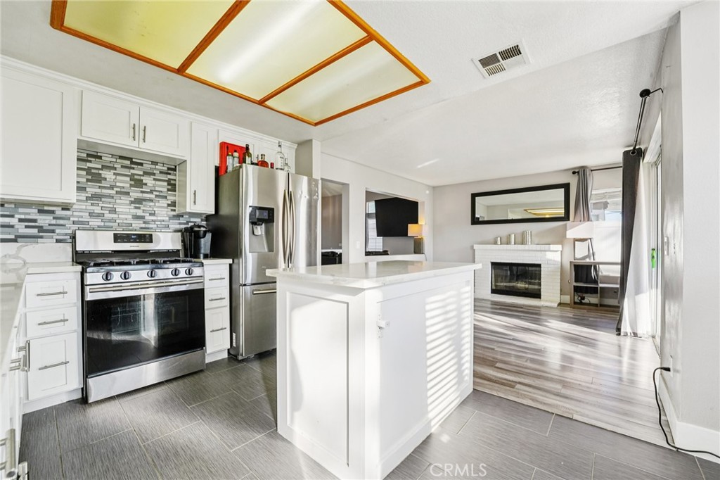 17586 Mountain Court Riverside, CA 92503 - Photo 9 of 39 a kitchen with stainless steel appliances kitchen island granite countertop a stove and a refrigerator