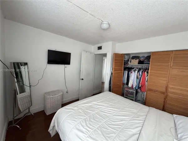 a bedroom with a bed and a flat screen tv
