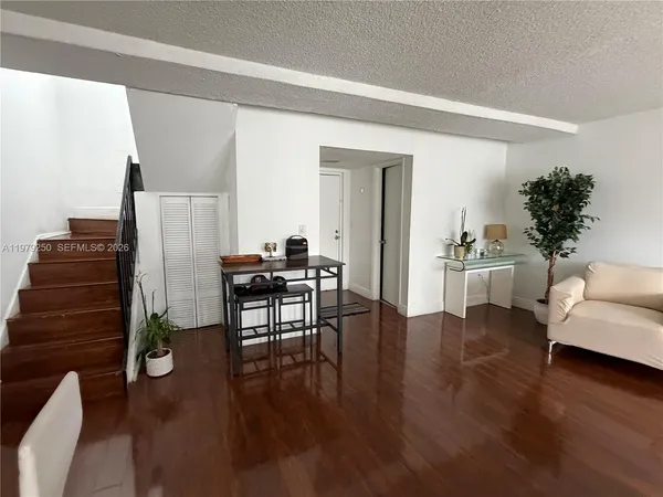 a living room with furniture a wooden floor and a piano