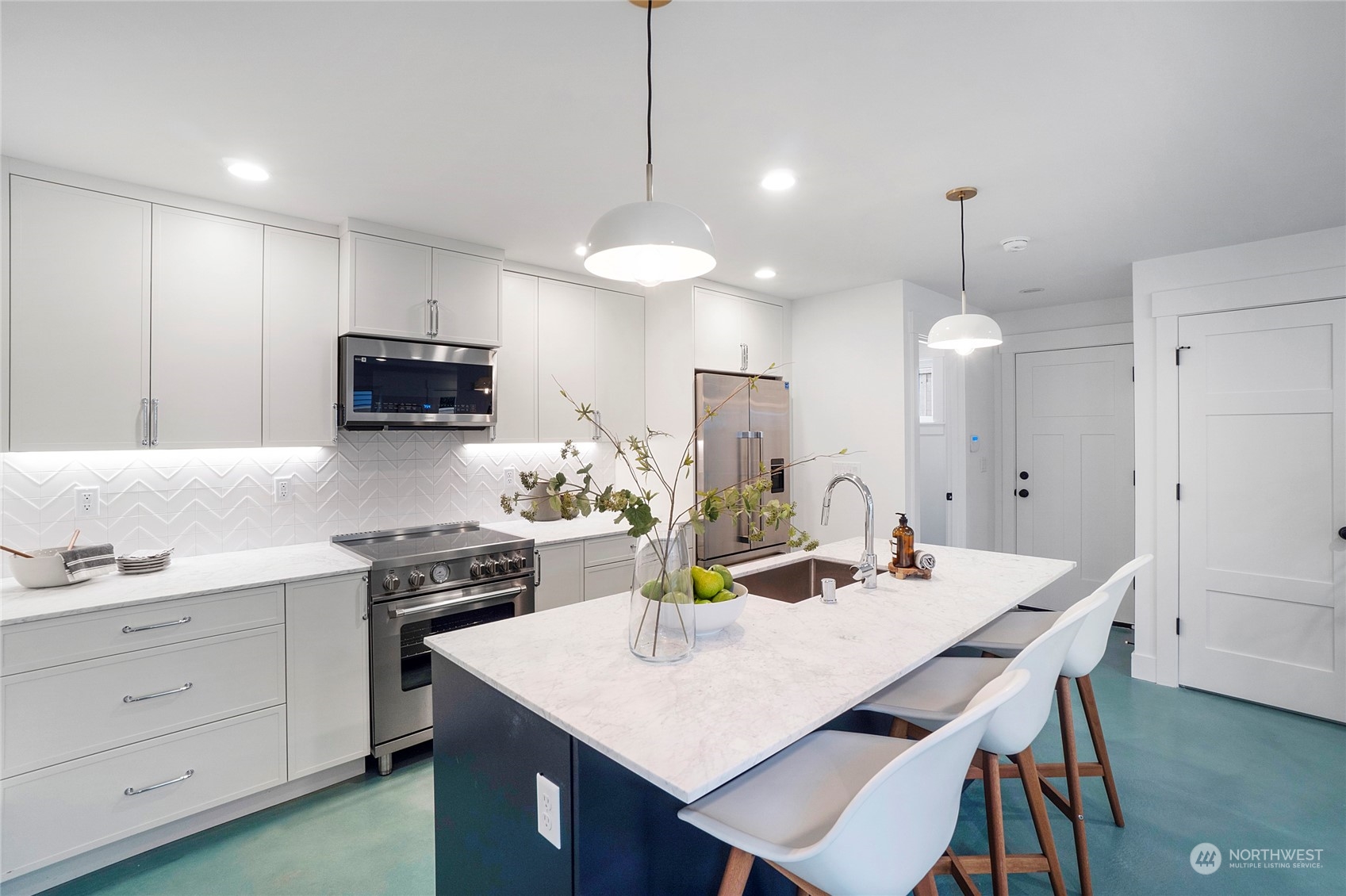 1619 3rd Avenue West Seattle, WA 98119 - Photo 5 of 28 a kitchen with a dining table chairs stainless steel appliances and cabinets