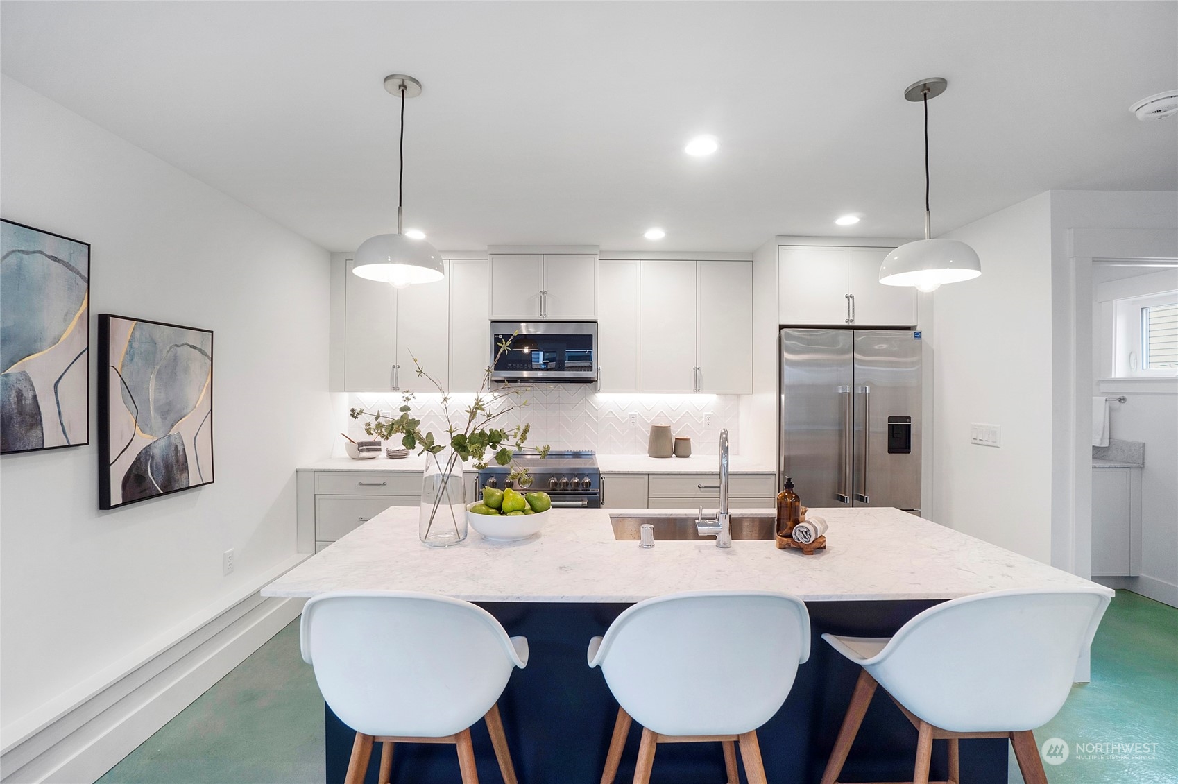 1619 3rd Avenue West Seattle, WA 98119 - Photo 6 of 28 a kitchen with stainless steel appliances a dining table chairs and white cabinets