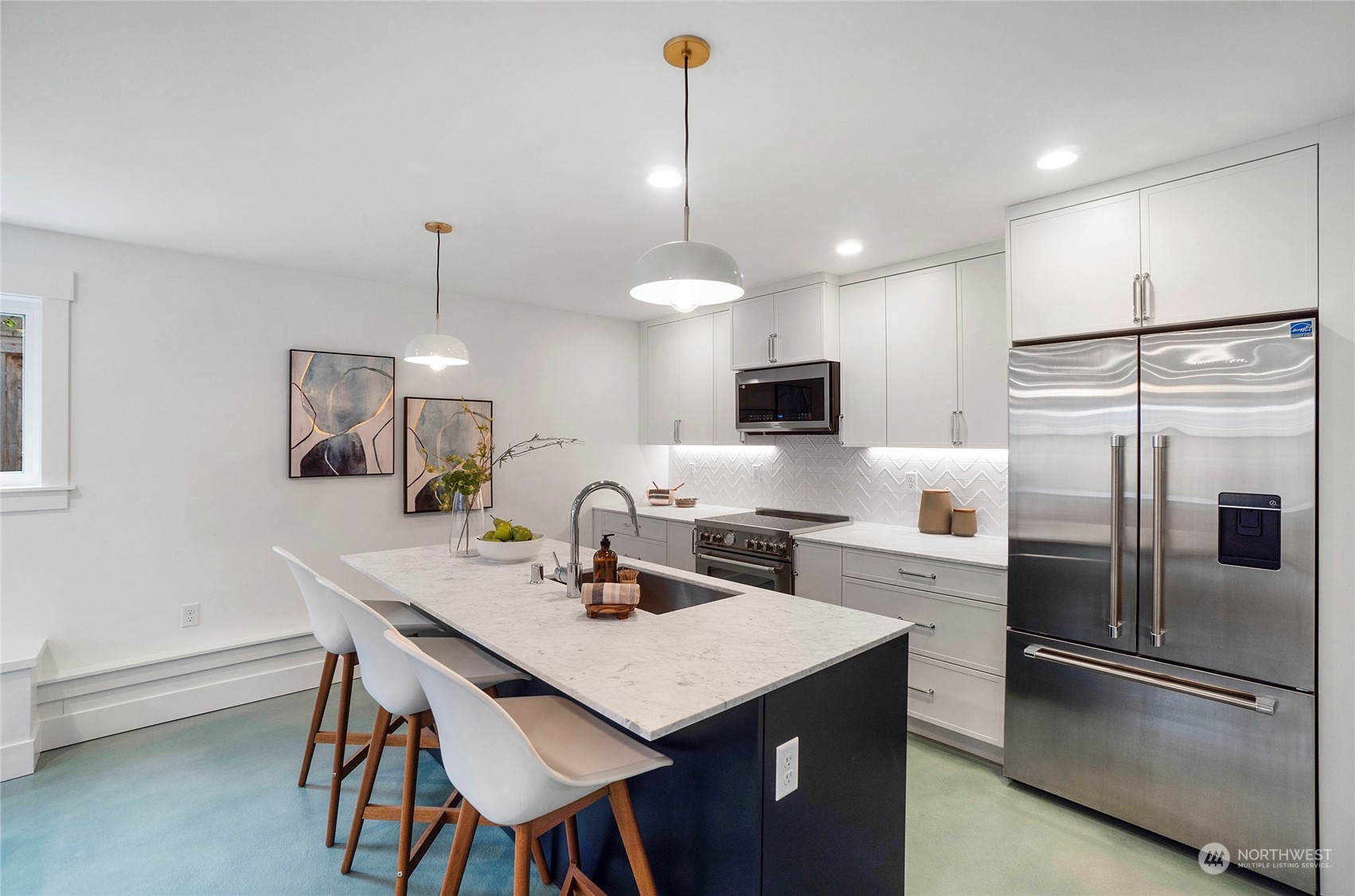 1619 3rd Avenue West Seattle, WA 98119 - Photo 7 of 28 a kitchen with stainless steel appliances a dining table chairs refrigerator and microwave