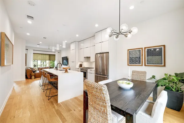 a view of a dining room with furniture a chandelier and wooden floor