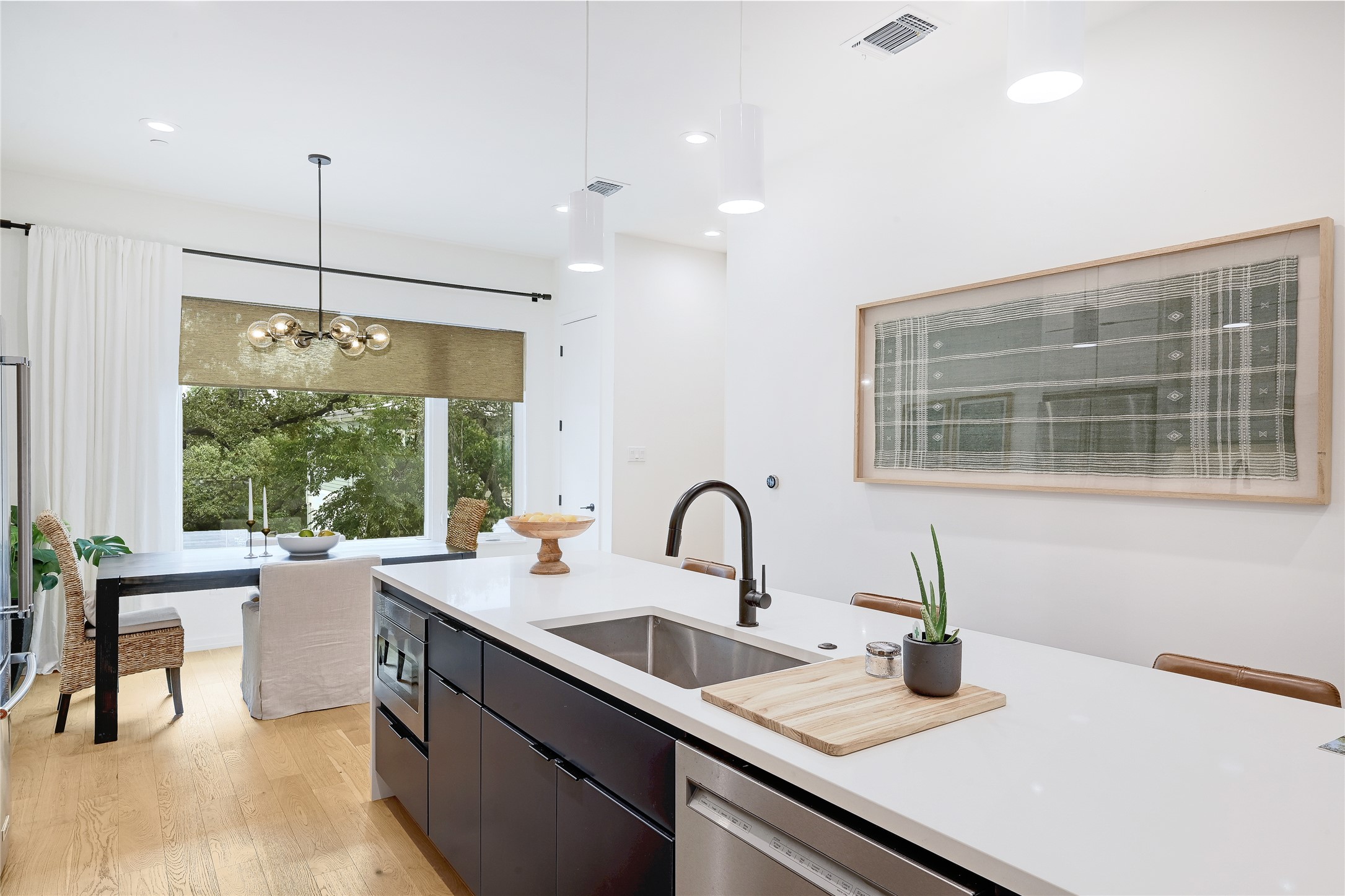 410 West Alpine Road, Unit 7 Austin, TX 78704 - Photo 7 of 26 a kitchen with kitchen island a large window cabinets a sink and stainless steel appliances