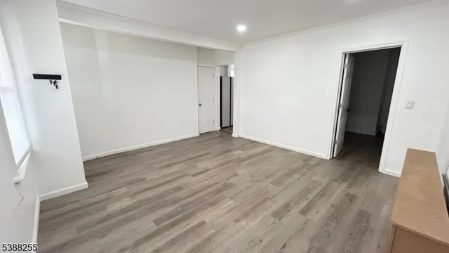 an empty room with wooden floor and entrance