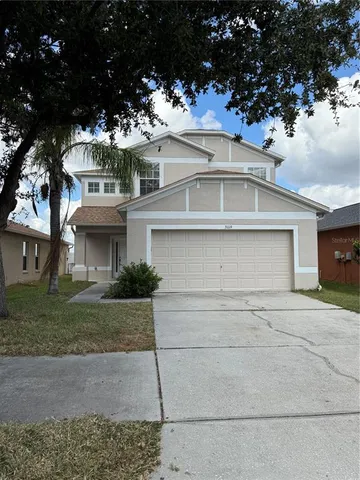 a view of a white house with a large tree