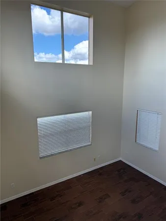 a view of a small space with wooden floor and a window