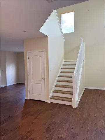 a view of a hallway with wooden floor and entryway