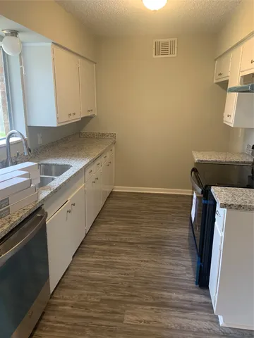 a kitchen with a sink and wooden floor