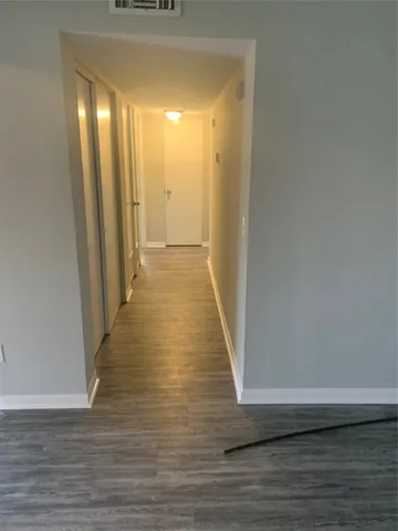 a view of a room with wooden floor