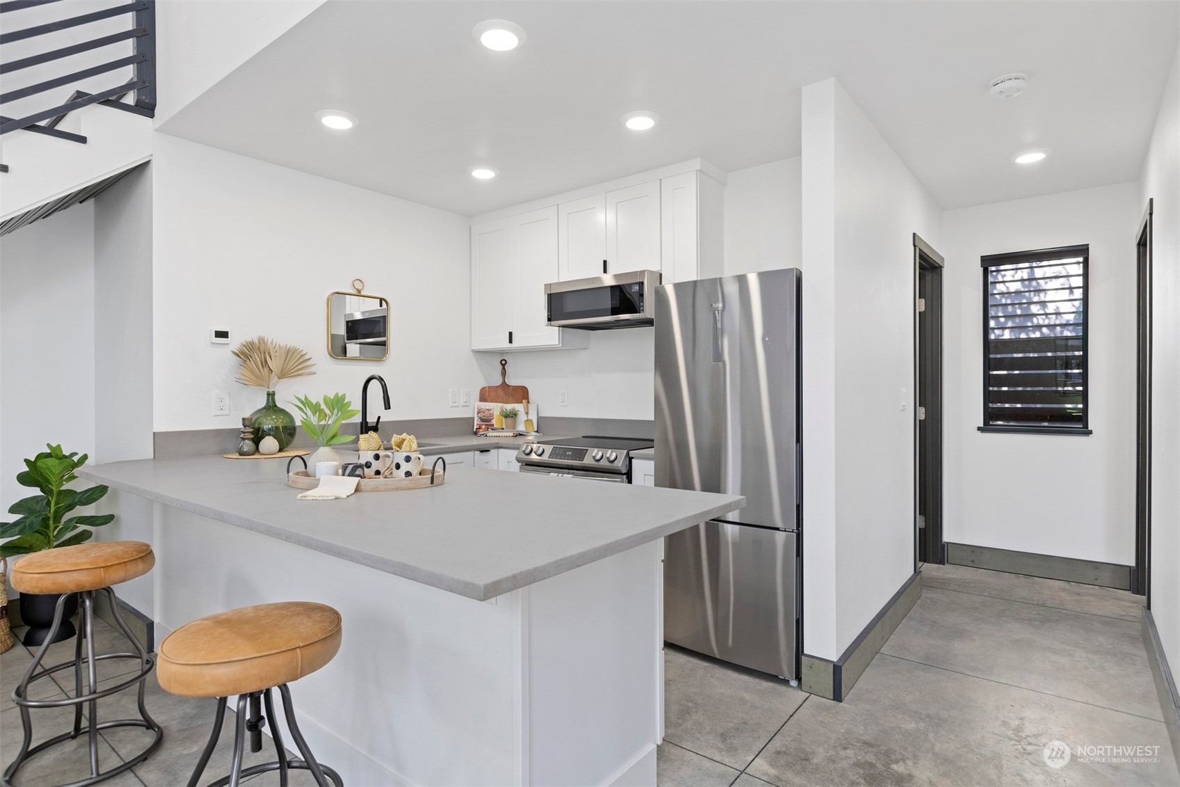 2415 Pacific Street Bellingham, WA 98229 - Photo 13 of 40 a kitchen with stainless steel appliances a refrigerator a sink a stove a dining table and chairs