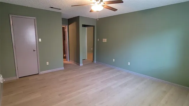 an empty room with closet and a chandelier fan