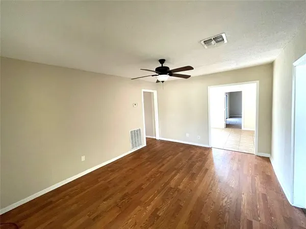 a view of empty room with wooden floor