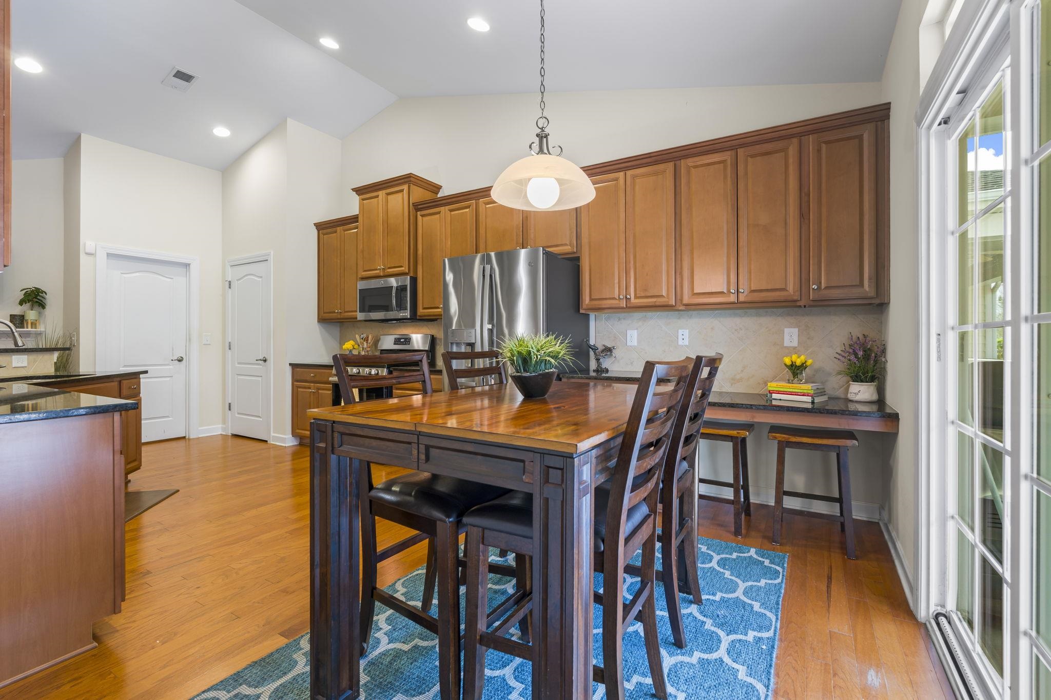 2015 Oxford Street Myrtle Beach, SC 29577 - Photo 14 of 40 Kitchen featuring brown cabinetry, pendant lighting, tasteful backsplash, appliances with stainless steel finishes, and light wood-style flooring