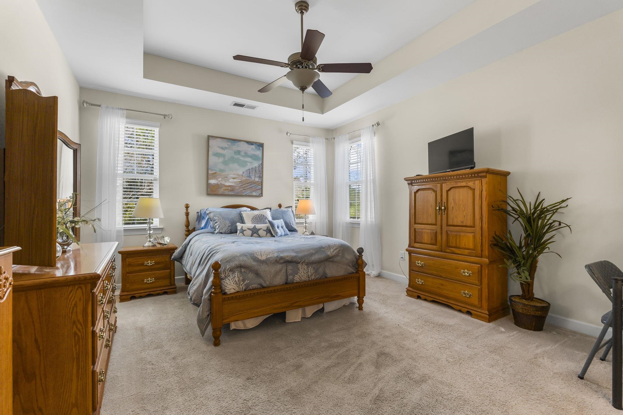 2015 Oxford Street Myrtle Beach, SC 29577 - Photo 17 of 40 Bedroom with a tray ceiling, light carpet, and a ceiling fan
