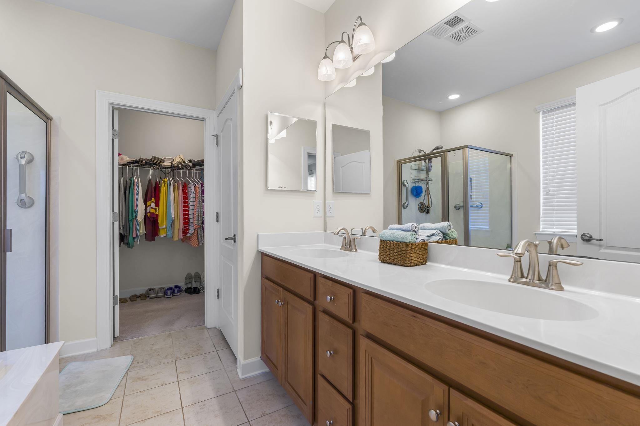2015 Oxford Street Myrtle Beach, SC 29577 - Photo 20 of 40 Full bathroom with a shower stall, double vanity, a walk in closet, and light tile patterned flooring