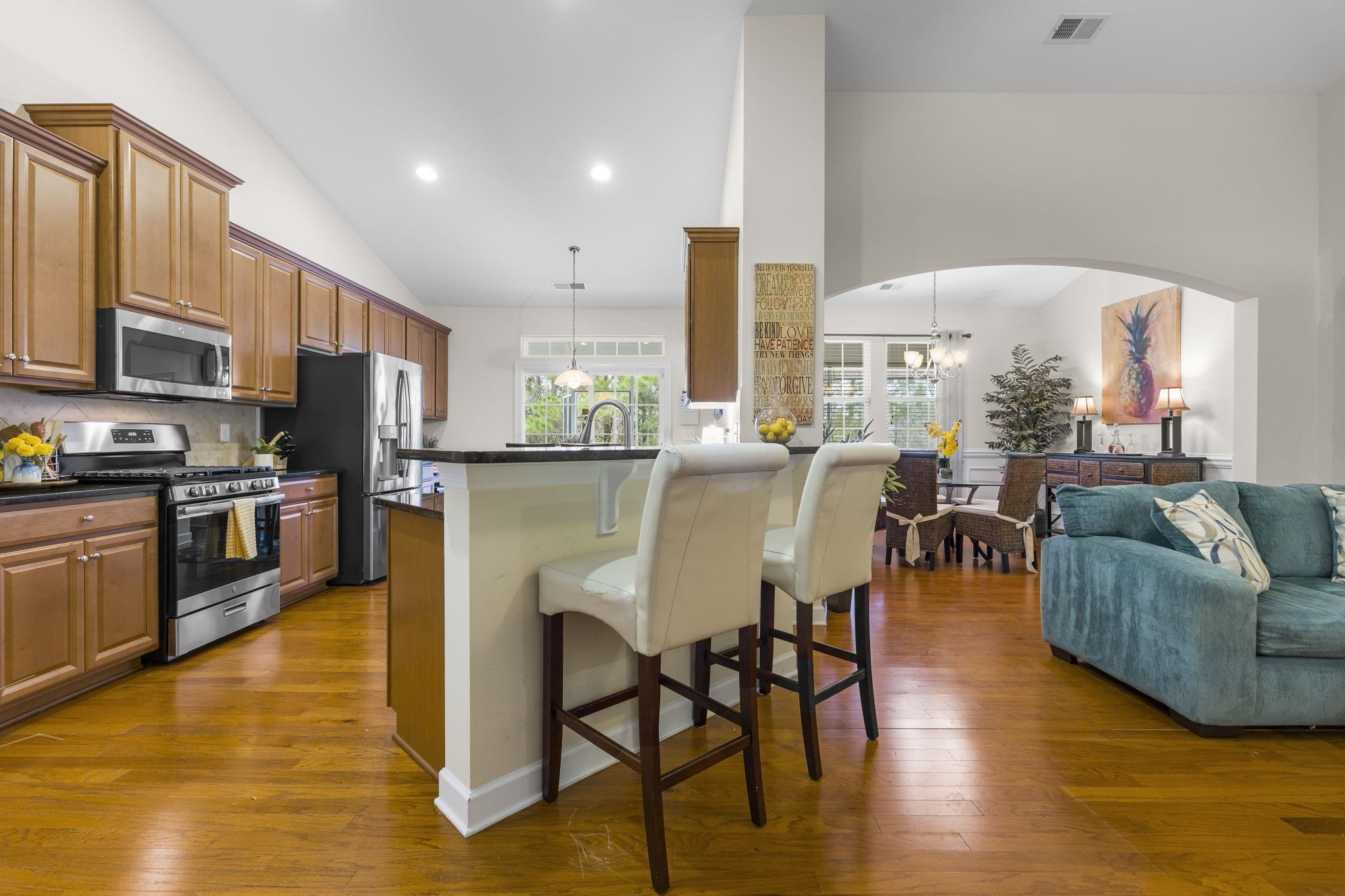 2015 Oxford Street Myrtle Beach, SC 29577 - Photo 39 of 40 Kitchen featuring open floor plan, stainless steel appliances, brown cabinets, a breakfast bar, and high vaulted ceiling