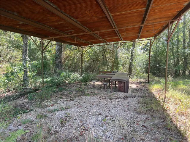 a view of a backyard with table and chairs under an umbrella
