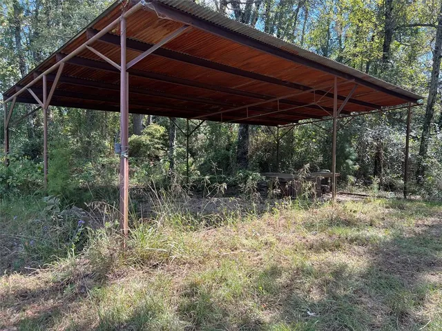 a backyard of a house with table and chairs under an umbrella