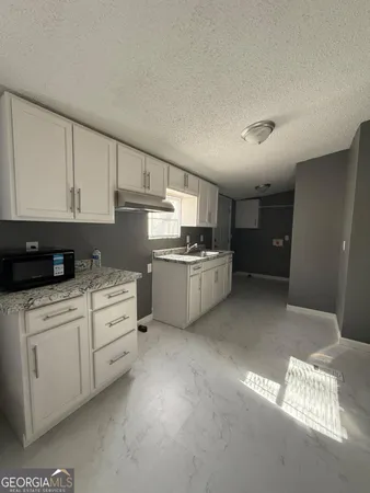 a kitchen with stainless steel appliances granite countertop a refrigerator sink and white cabinets