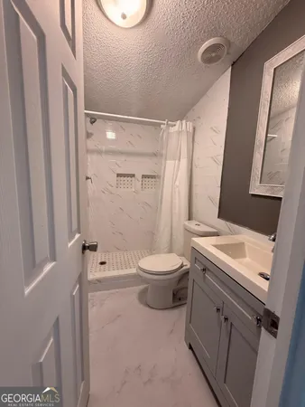 a bathroom with a sink toilet and mirror