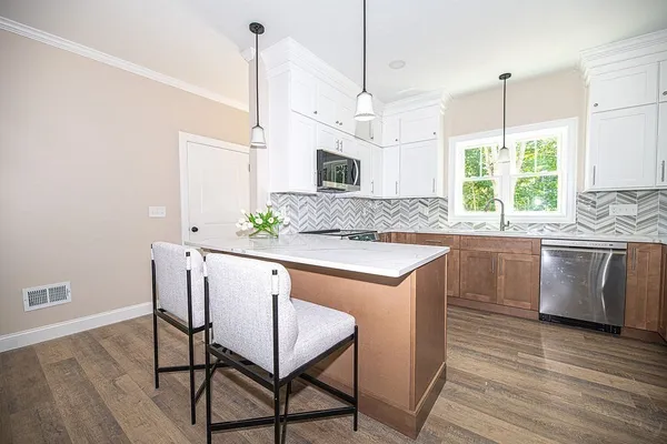 a kitchen with a table chairs sink and cabinets