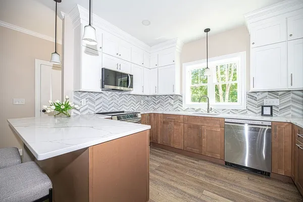 a kitchen with stainless steel appliances granite countertop a sink a stove and a wooden floor