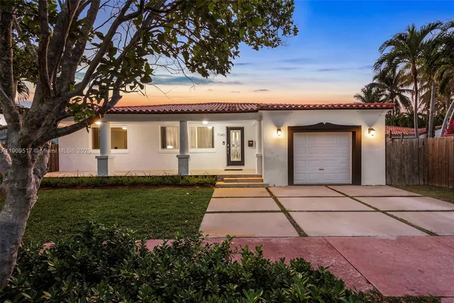 a backyard of a house with plants and palm tree