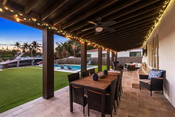 a view of a patio with a dining table and chairs with a barbeque grill