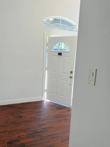 an empty room with wooden floor and mirror