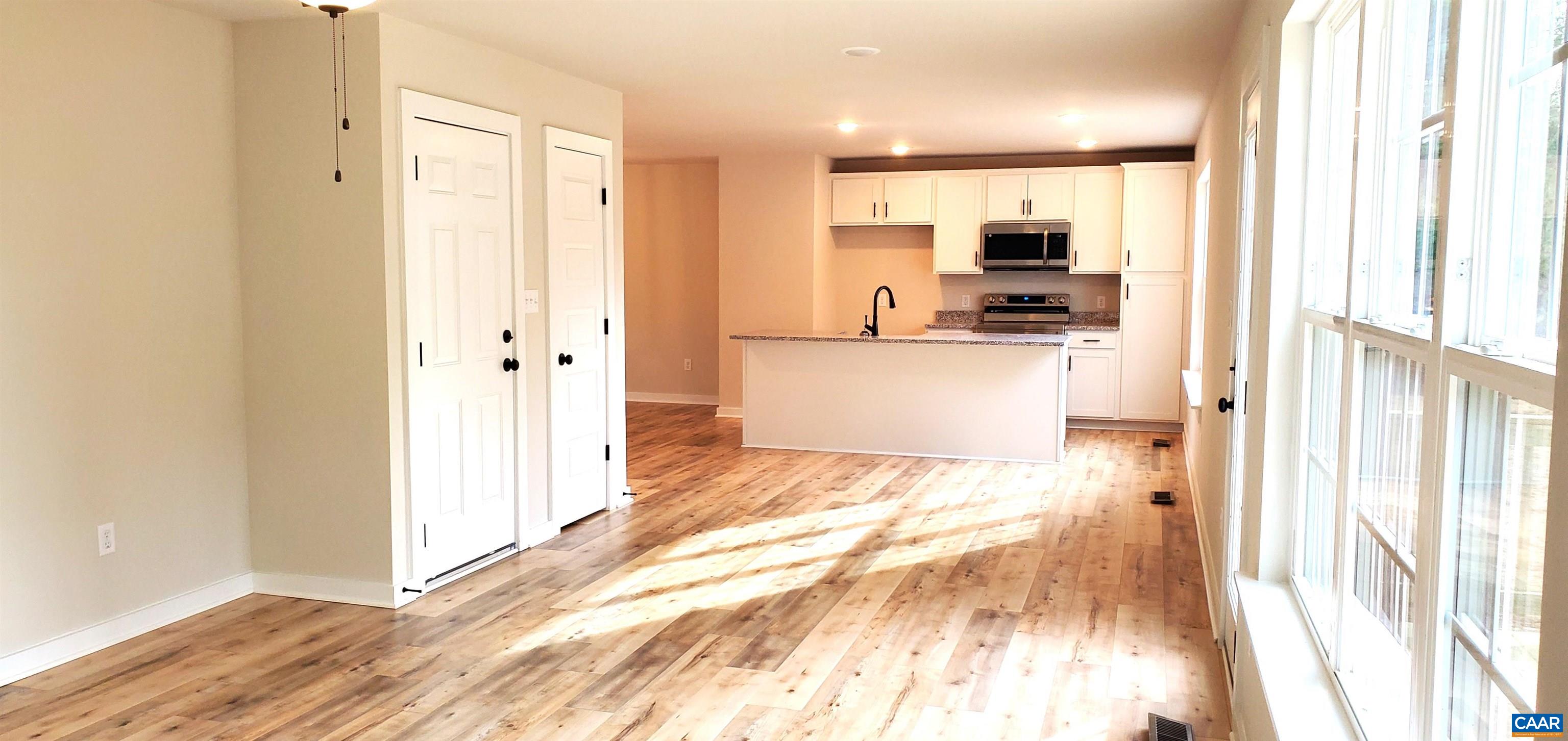 4245 Roundabout Road Louisa, VA 23093 - Photo 15 of 36 a view of a kitchen with kitchen island granite countertop wooden floor and a refrigerator