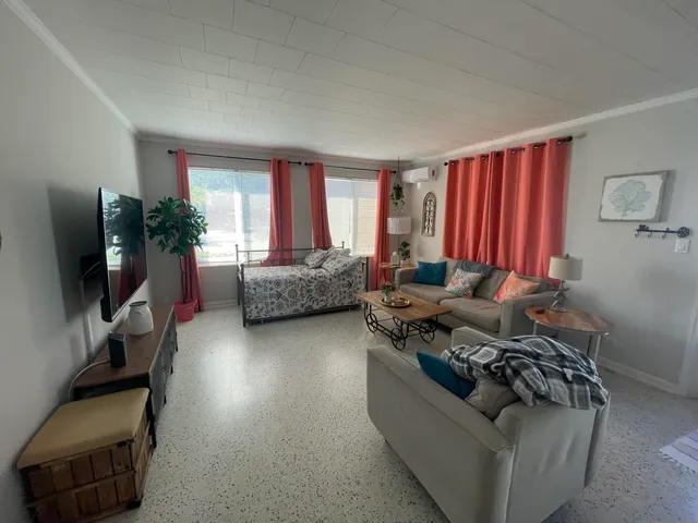 a living room with furniture window and a flat screen tv
