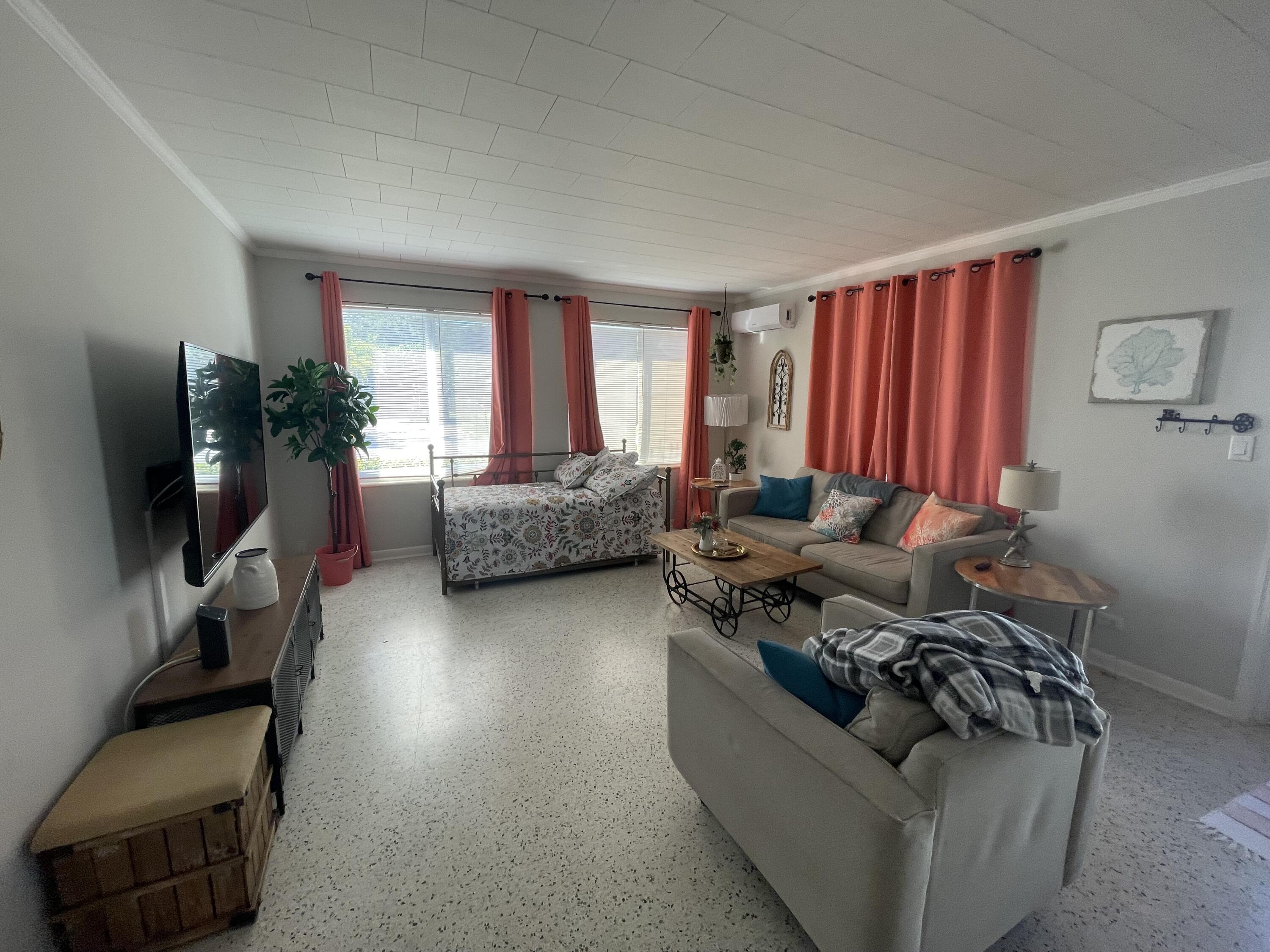 2023 South Suzanne Circle, Unit 1 North Palm Beach, FL 33408 - Photo 3 of 10 a living room with furniture window and a flat screen tv