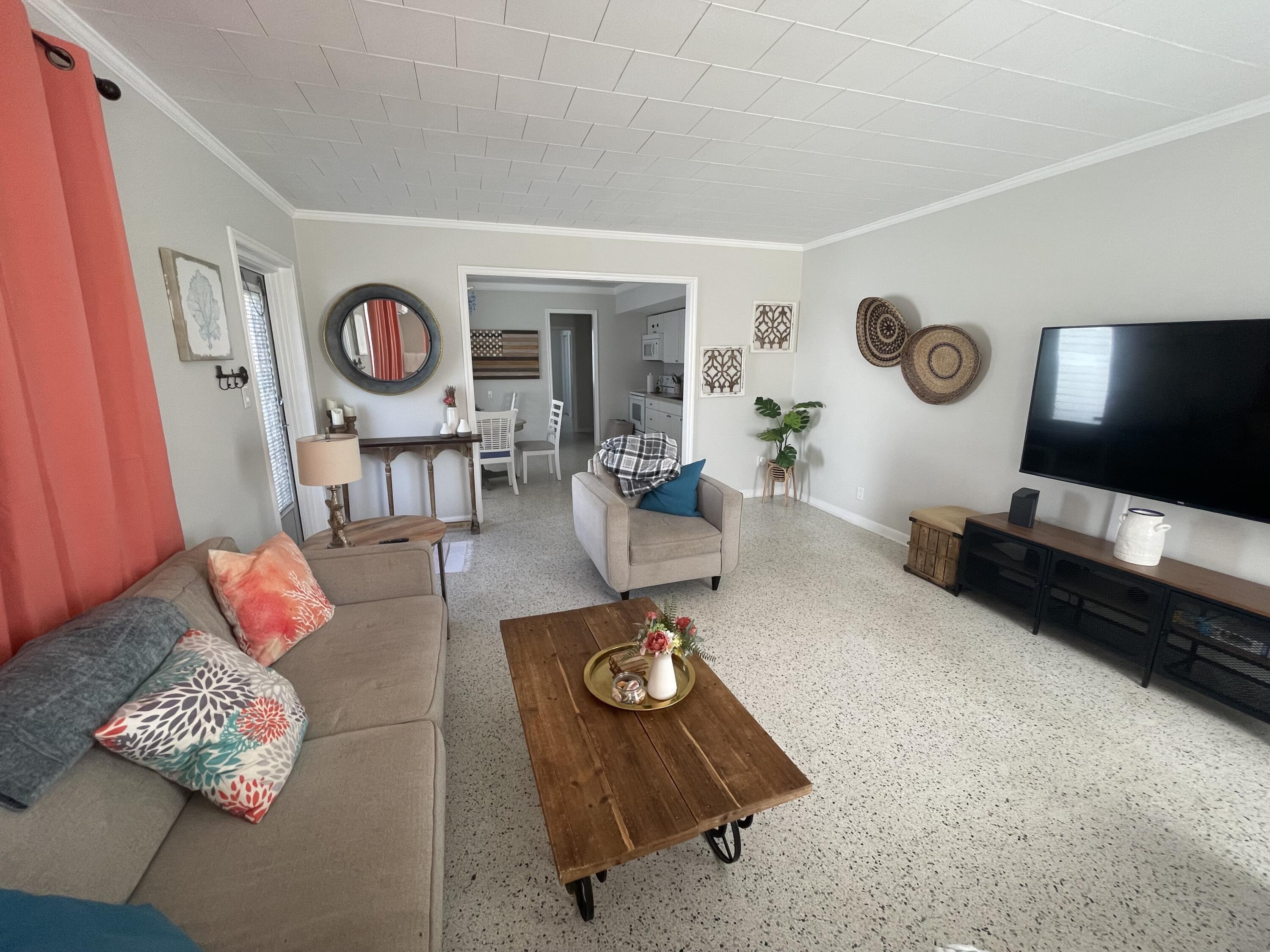 2023 South Suzanne Circle, Unit 1 North Palm Beach, FL 33408 - Photo 4 of 10 a living room with furniture and a flat screen tv