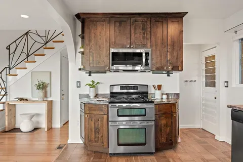 a kitchen with stainless steel appliances a stove a microwave and a refrigerator