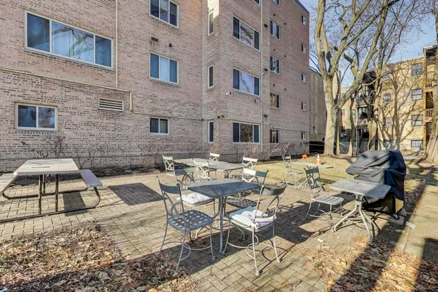 a view of a patio with couches table and chairs under an umbrella